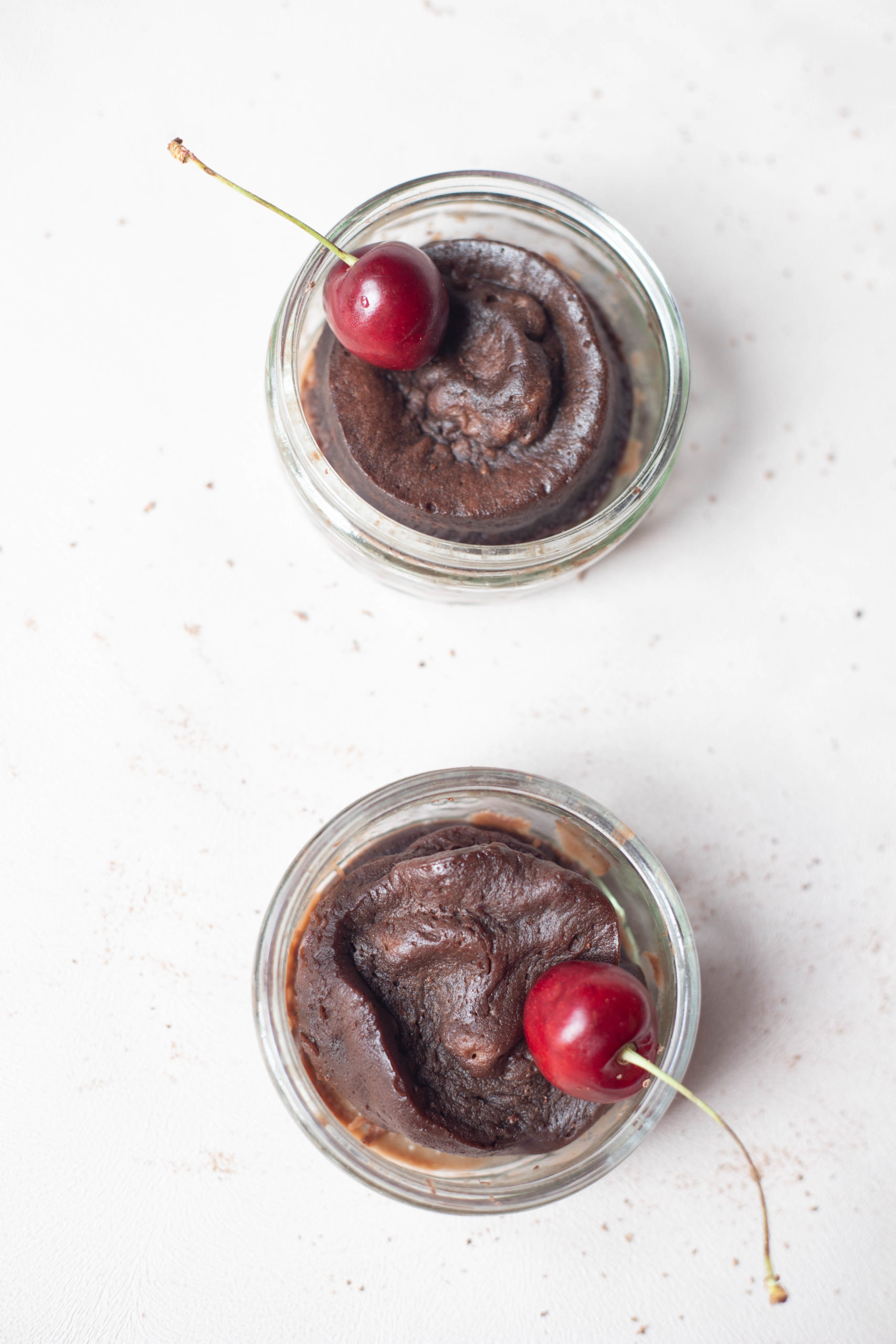 2 chocolate mug cakes with cherries on top