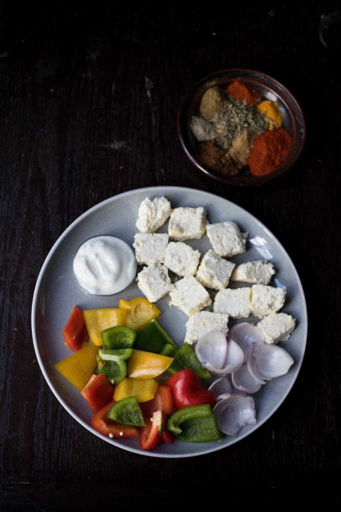 paneer, bell peppers, yogurt on a plate along with spice powders