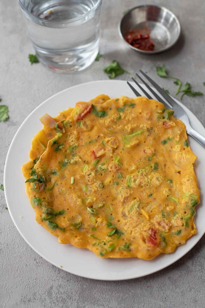 vegan chickpea flour omelette served with a pickle and a glass of water.