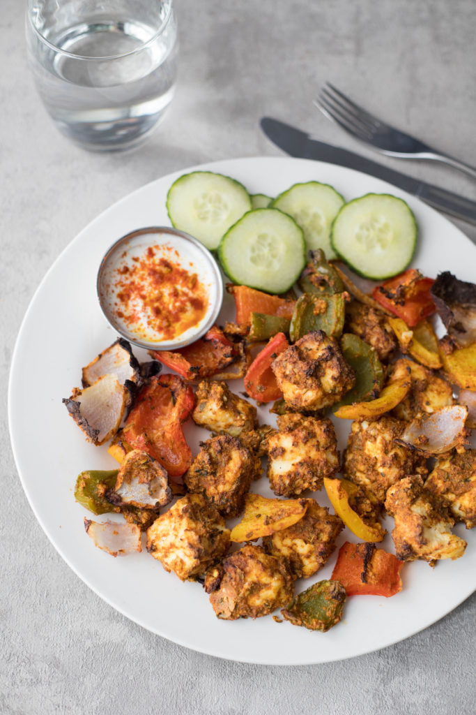 Paneer tikka served with a dip and salad