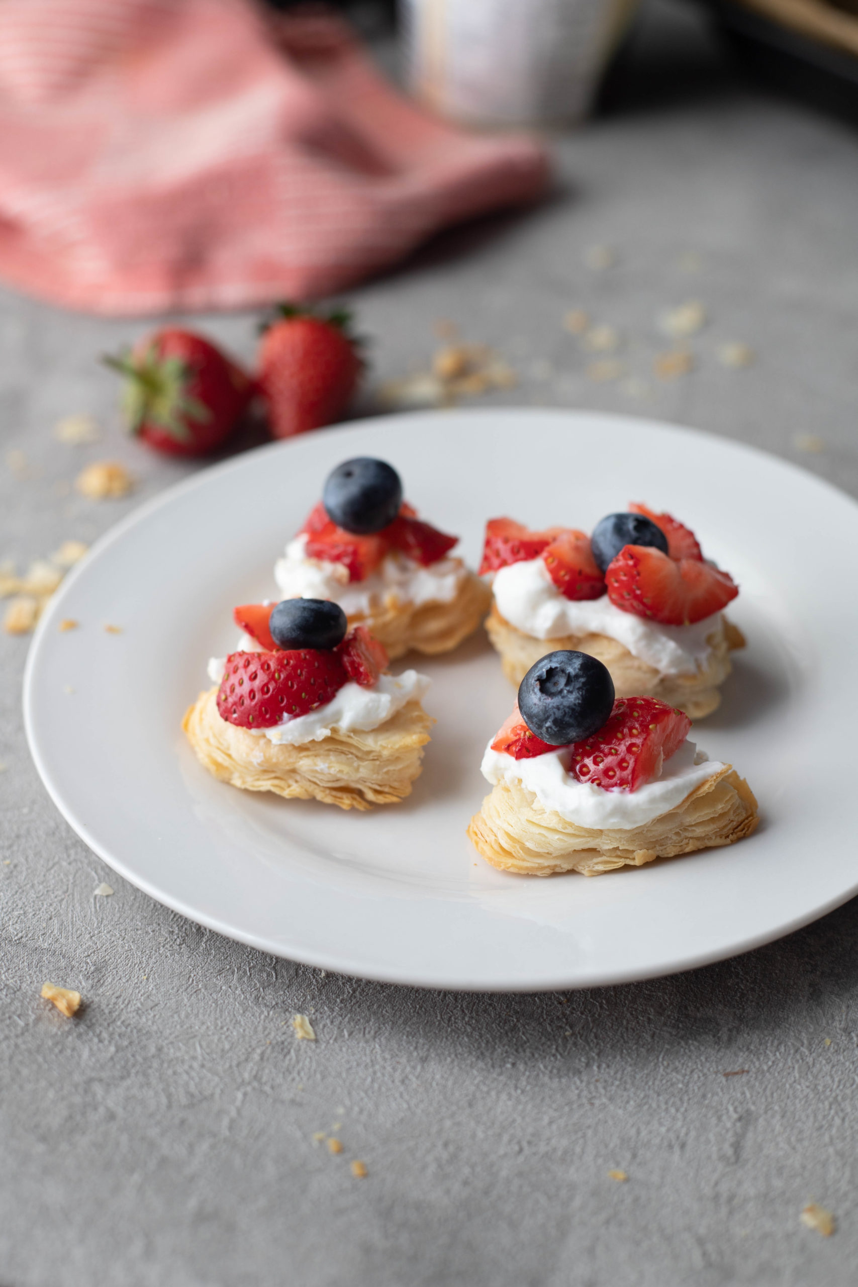 strawberry Puff pastry bites served with cream and berries