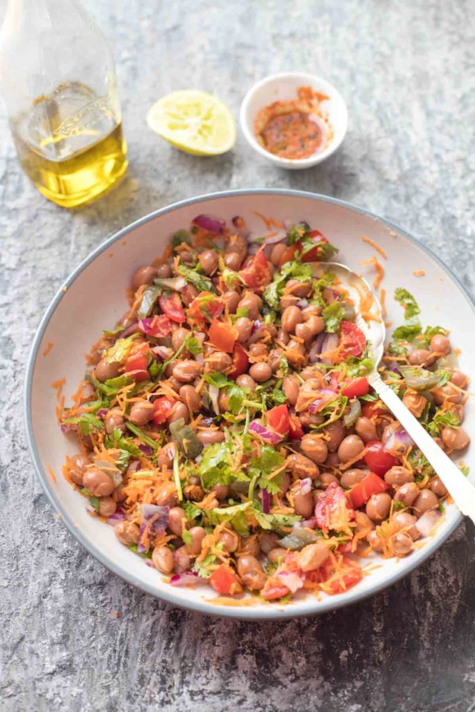 borlotti bean salad served in a large bowl with lime wedge and olive oil in the background