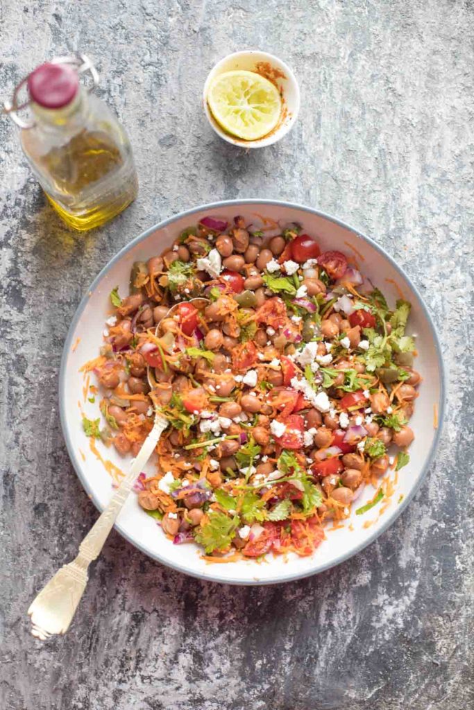 borlotti bean salad served in a large bowl with lime wedge and olive oil in the background