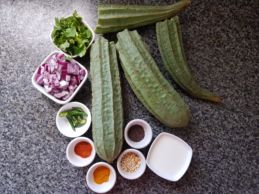 ingredients for ridge gourd curry , ridge gourd, chopped onions,green chilli, spice powders, mustard seeds, milk