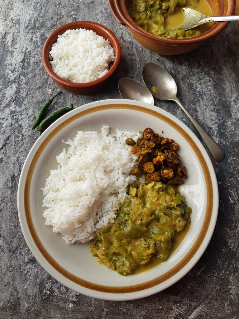 a plate of rice served with ridge gourd curry