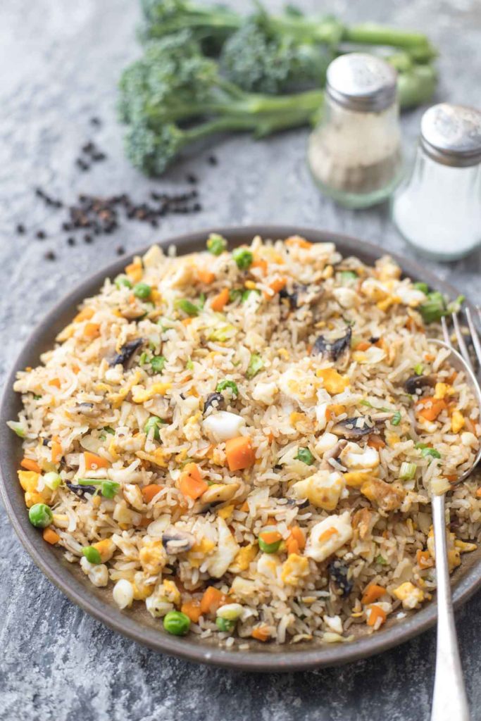 a plate f healthy fried rice with salt and pepper in the background