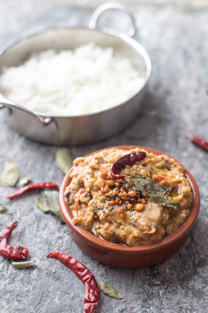 a bowl of kalchina vankaya pachadi i.r smoked eggplant chutney and a bowl of rice.