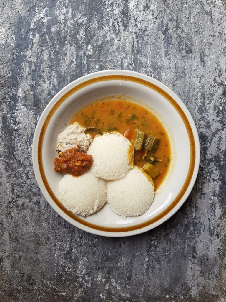 idlis served with sambar and chutneys