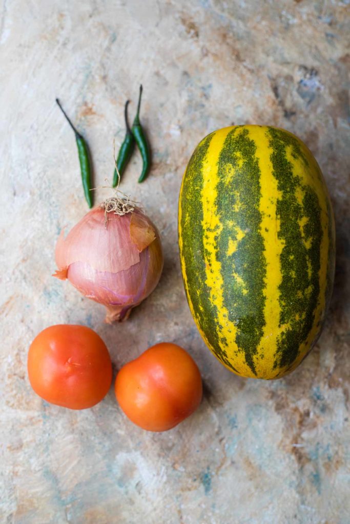 ingredients for dosakaya curry , yellow cucumber, tomatoes, onion, green chilli