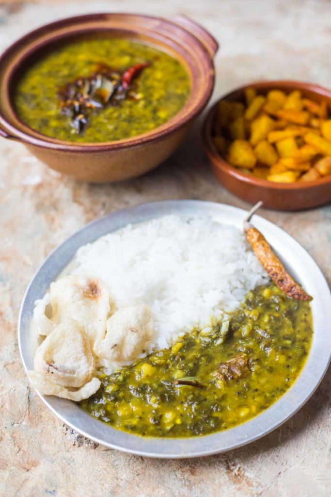 a plate of gogura pappu served with rice and indian crackers