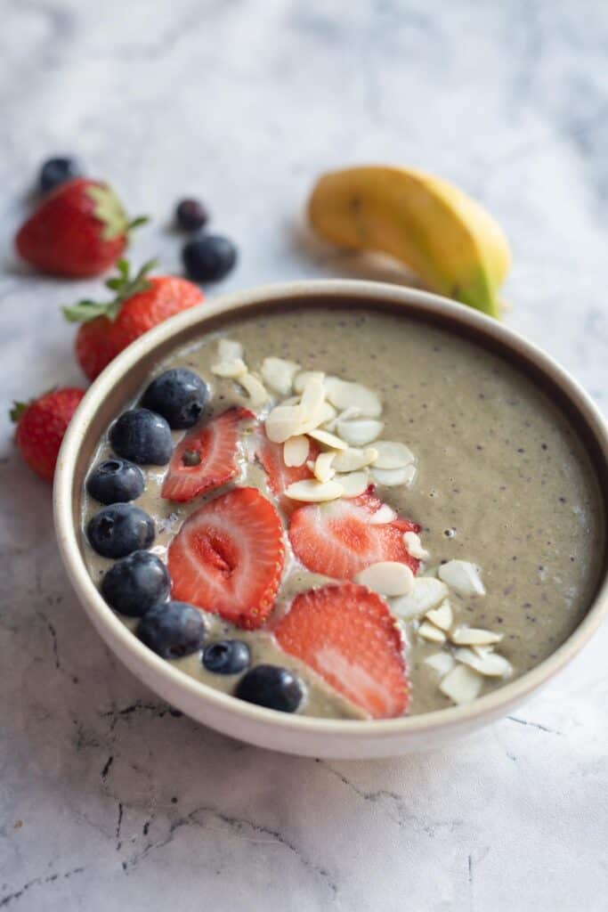 banana berry smoothie bowl topped with berries and almond flakes