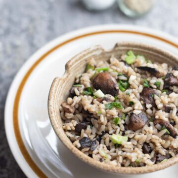 a bowl of mushroom fried rice with chopsticks