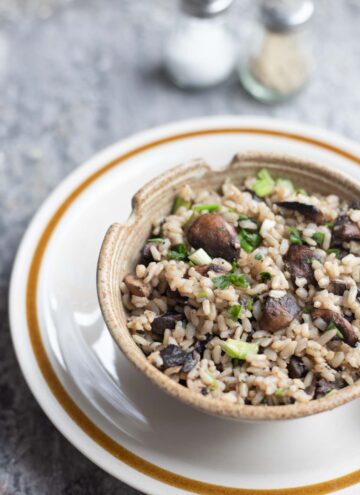 a bowl of mushroom fried rice with chopsticks