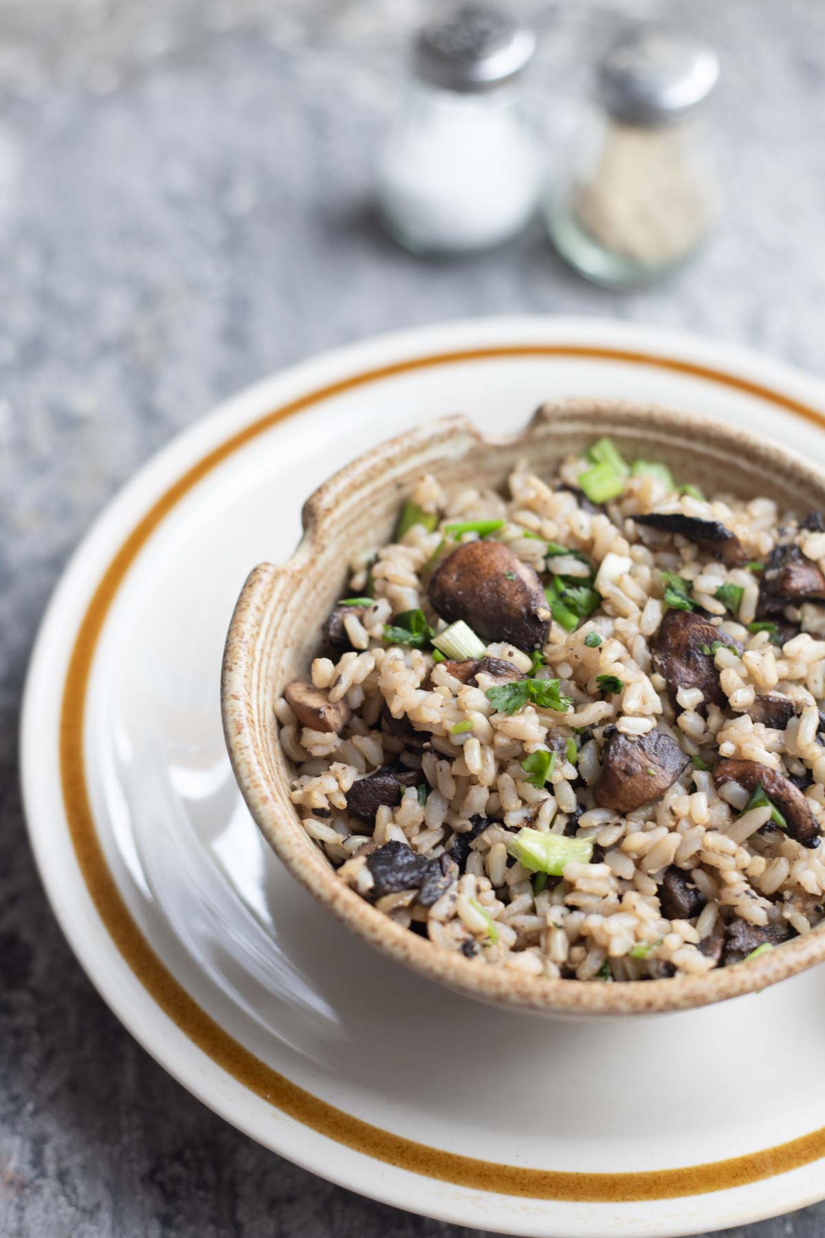 a bowl of mushroom fried rice with chopsticks