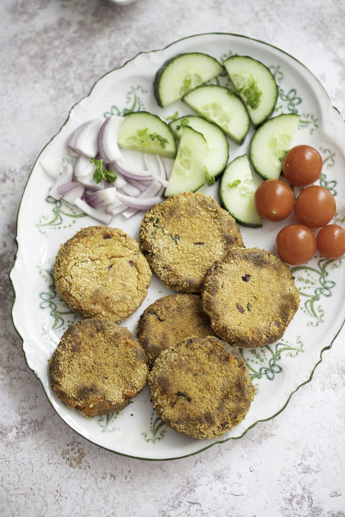 baked paneer cutlet served with salad on a plate