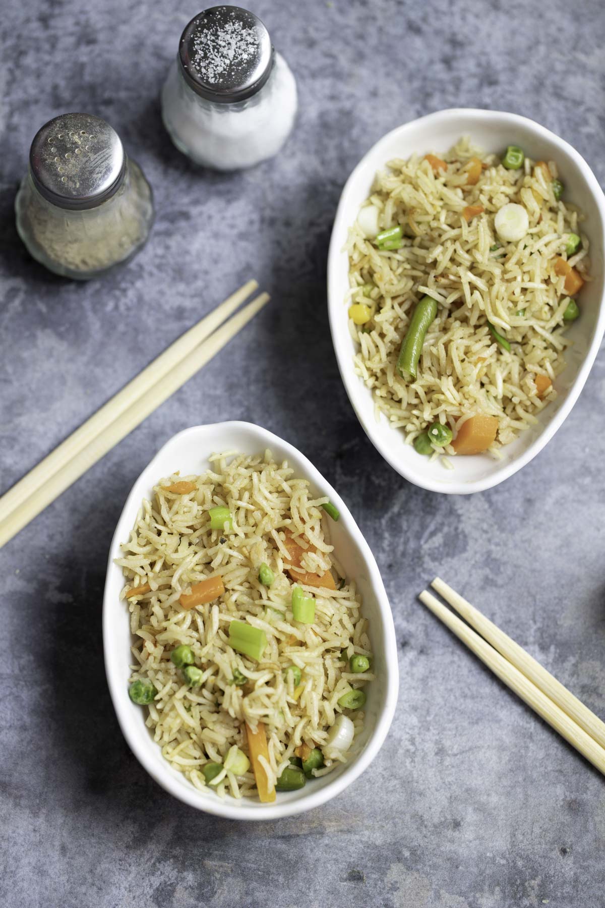 2 bowls of baked fried rice , 2 chopsticks, salt and pepper