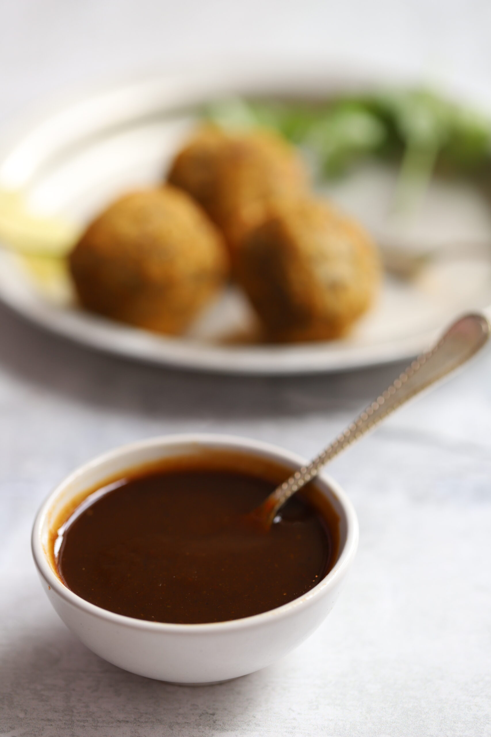 a small bowl of tamarind sauce with serving spoon