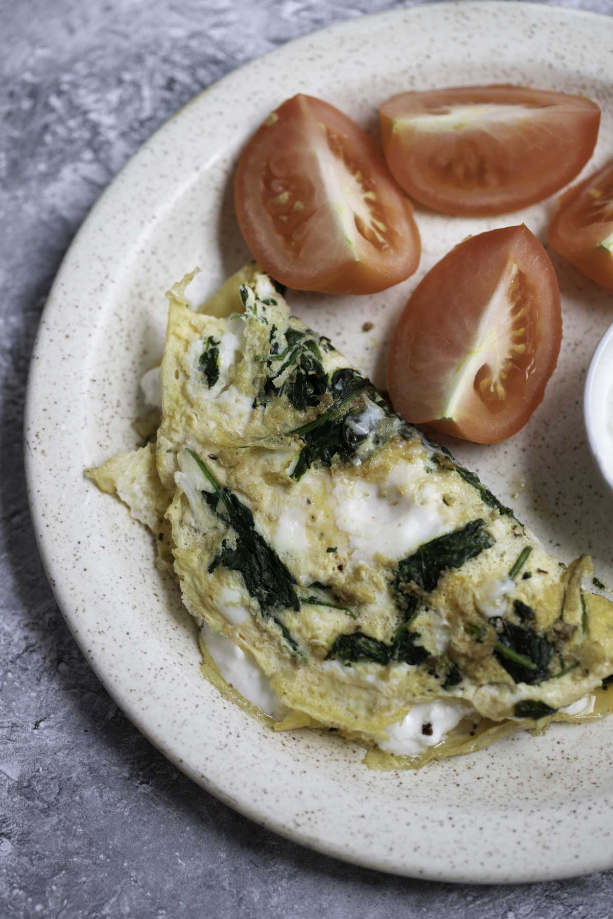 cottage cheese omelette  and tomatoes served on plate 