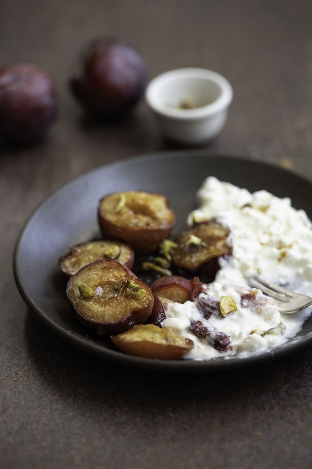 roasted plums served with cottage cheese and garnished with pistachios