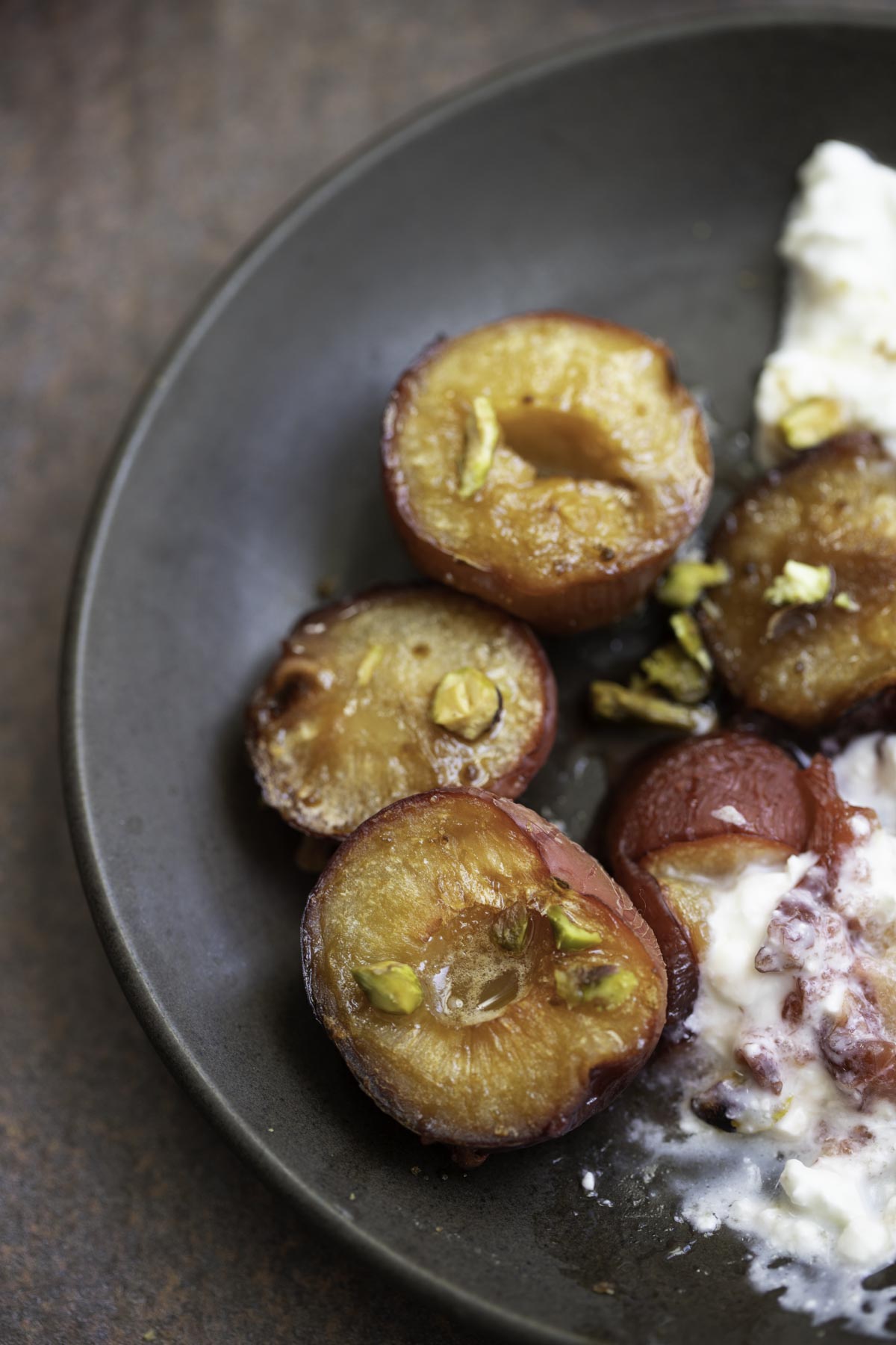 roasted plums on a black plate