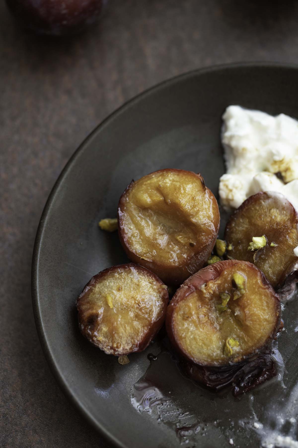 roasted plums with a drizzle of honey and garnished with pistachios